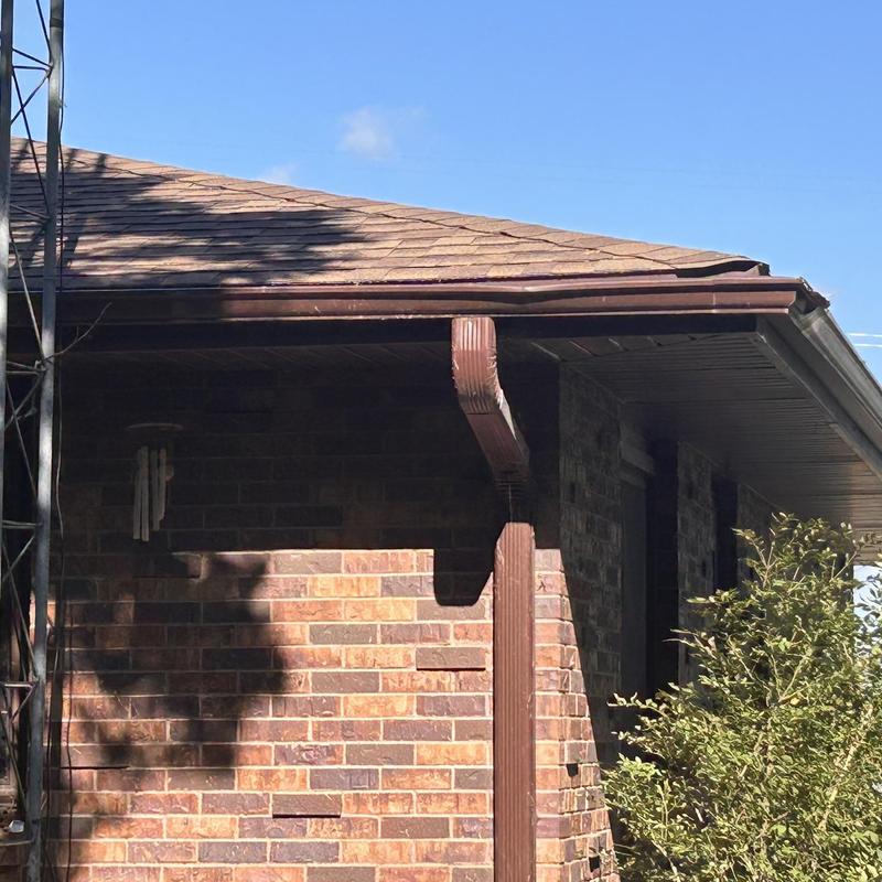 Aluminum gutters and downspout on brick house exterior Aluminum gutters and downspout on brick house exterior