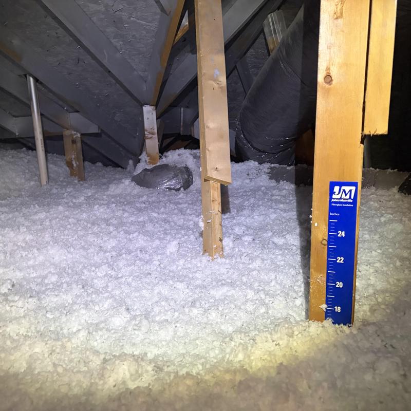 Attic loose-fill insulation with depth marker and ductwork