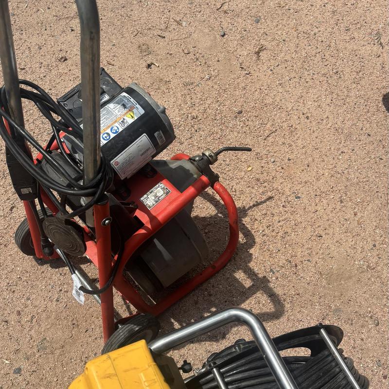 Drain line cleaning machine with cable reel on ground