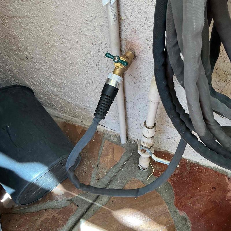Hose bib with attached garden hose and piping