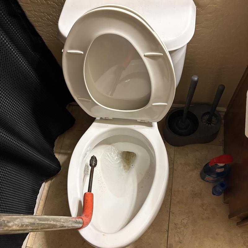 Toilet bowl auger clearing blockage in Glendale, AZ bathroom