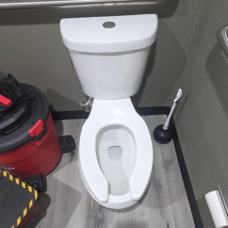 Commercial toilet with plunger and vacuum nearby Commercial toilet with plunger and vacuum nearby