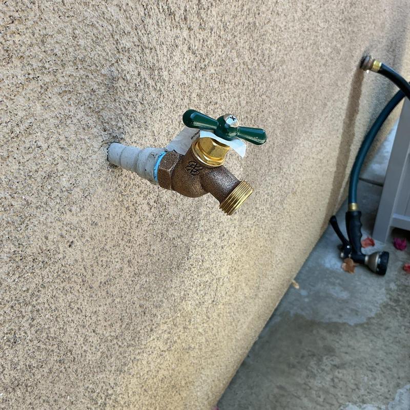 12 Hose bib with green handle on exterior wall