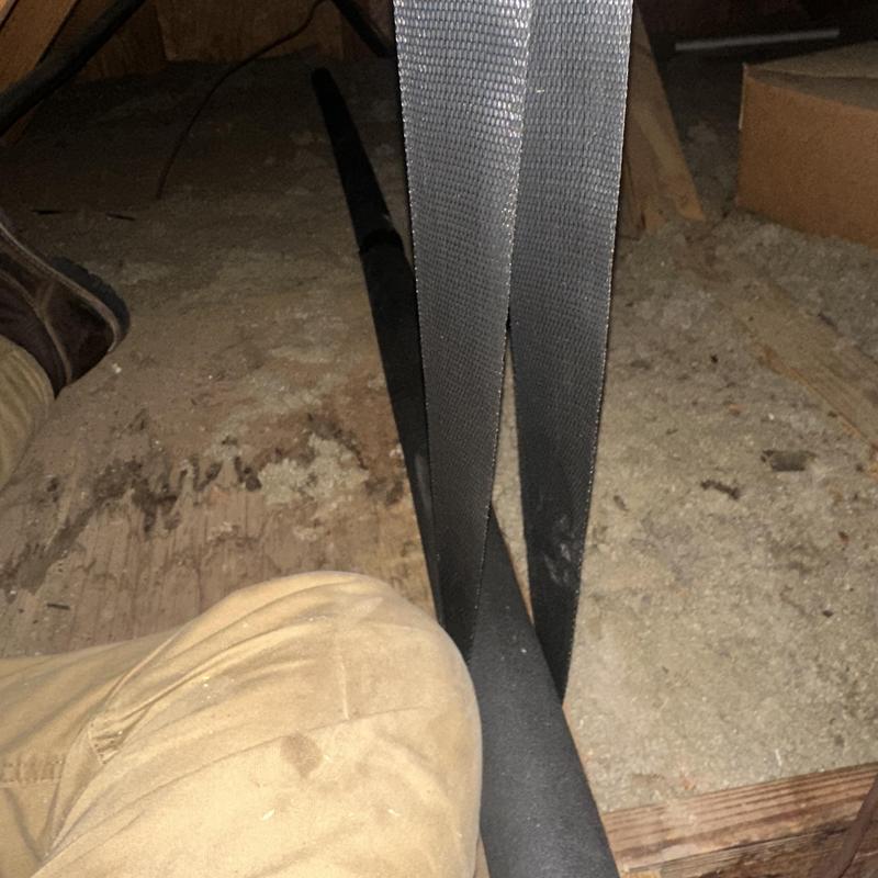 Drain line with new insulation strap in crawlspace