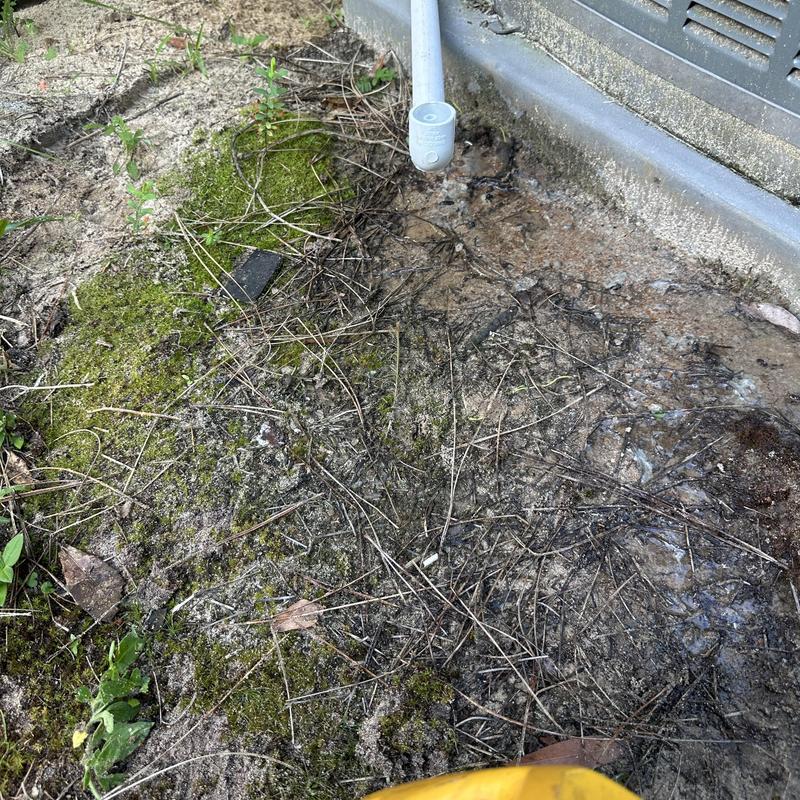 HVAC drain line with exterior pipe discharging condensation