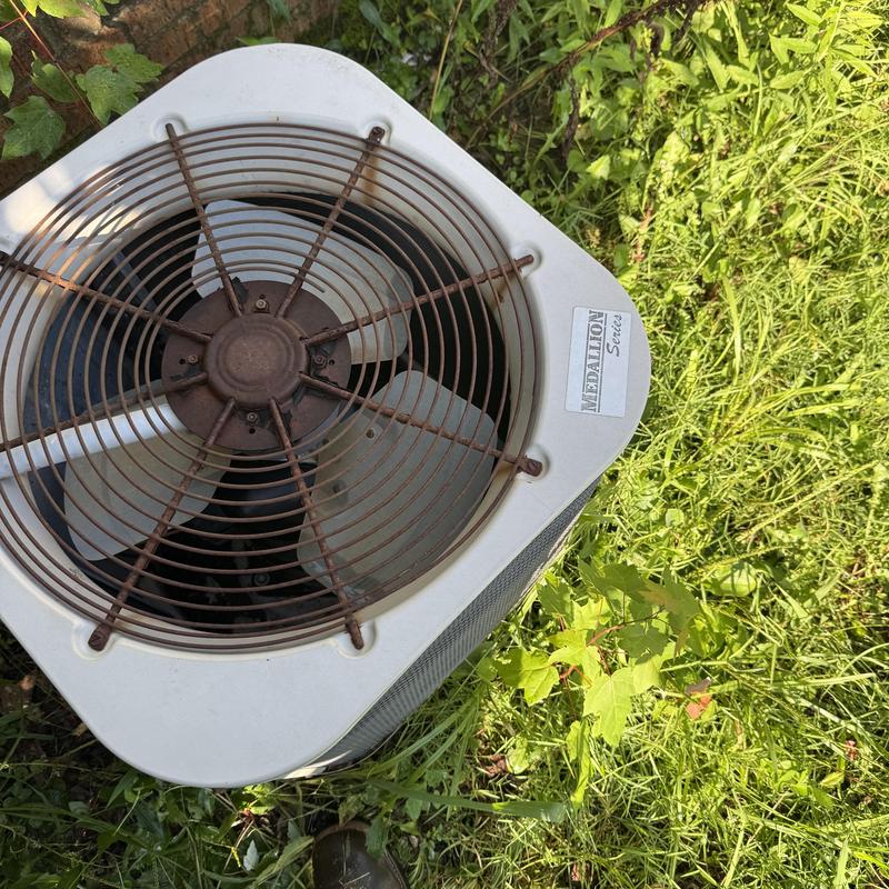 Outdoor air conditioner condenser unit in grass