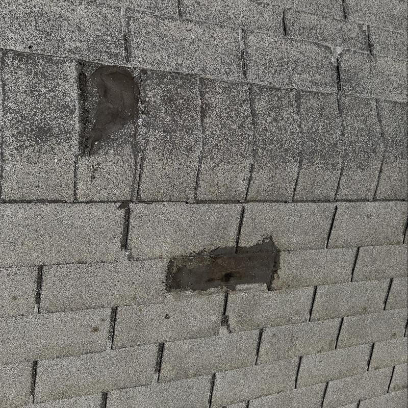 Shingle roof with patched and worn spots Shingle roof with patched and worn spots
