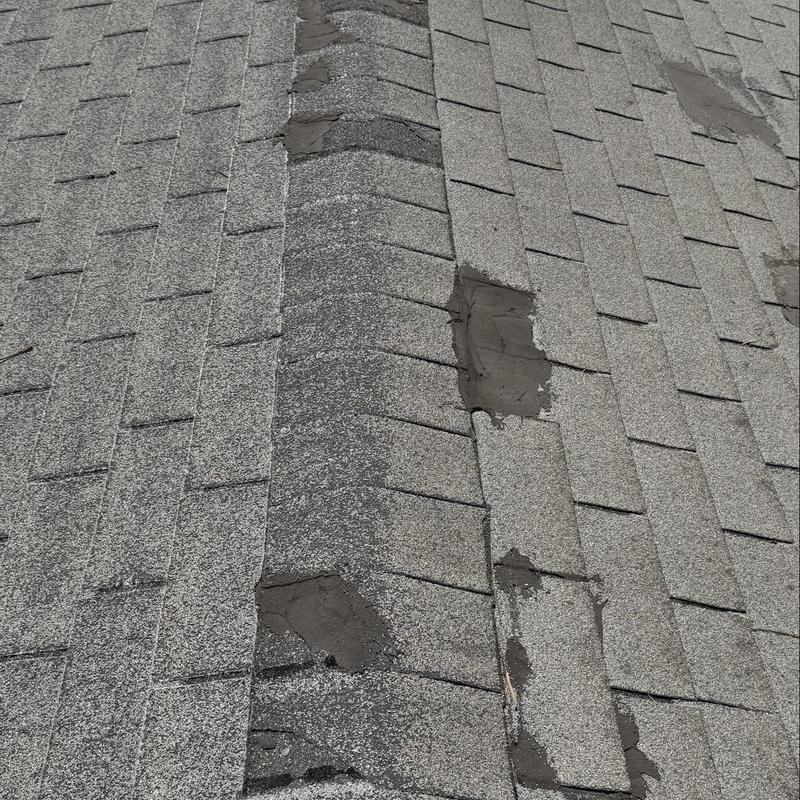 Shingle roof ridge with patch repairs and wear Shingle roof ridge with patch repairs and wear