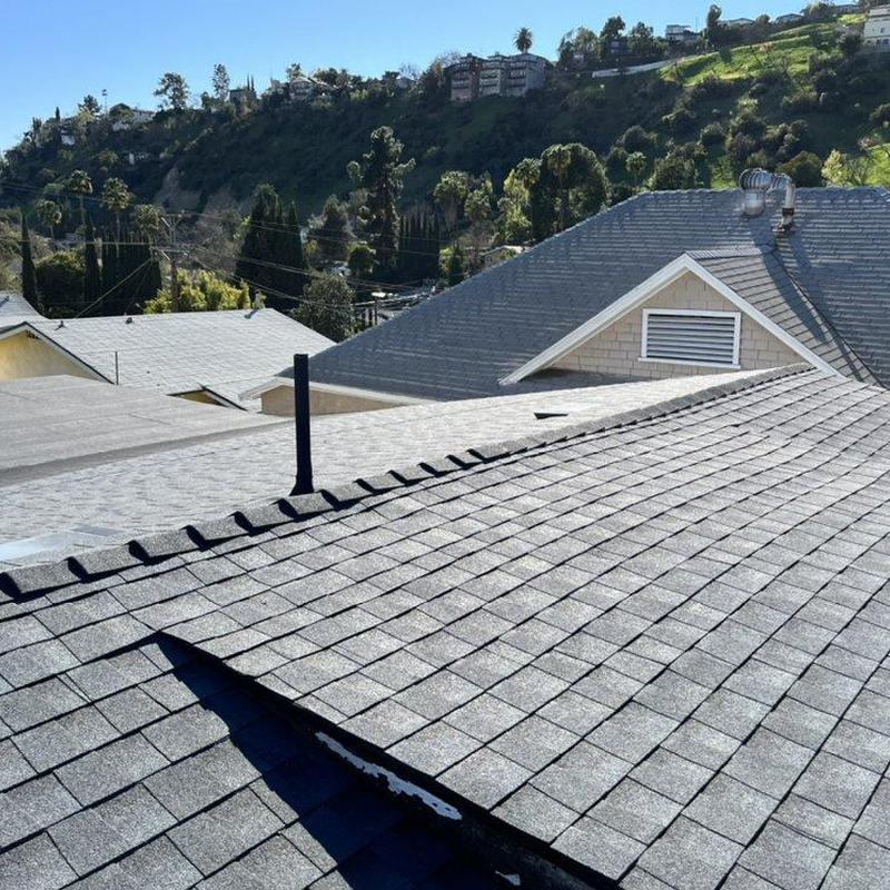 Asphalt shingle roof with ridge vents in sunny neighborhood Asphalt shingle roof with ridge vents in sunny neighborhood