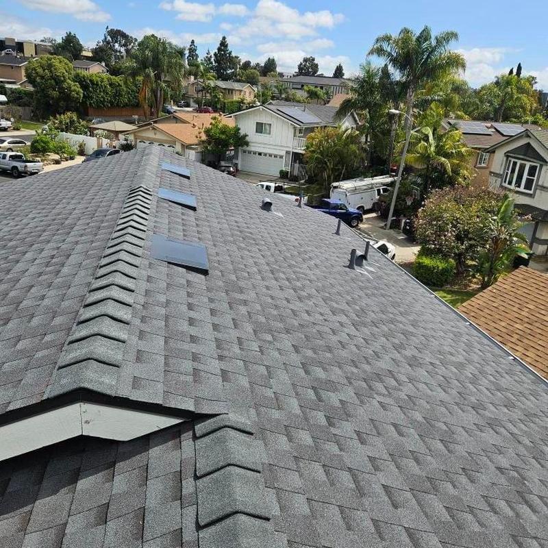New gray shingle roof with ridge vents on residential home New gray shingle roof with ridge vents on residential home