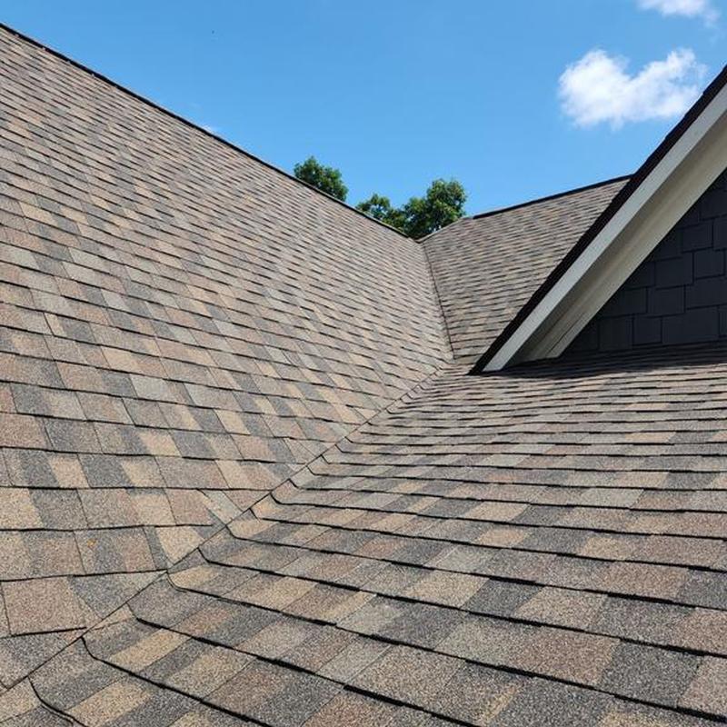 Asphalt shingle roof with valley under clear sky