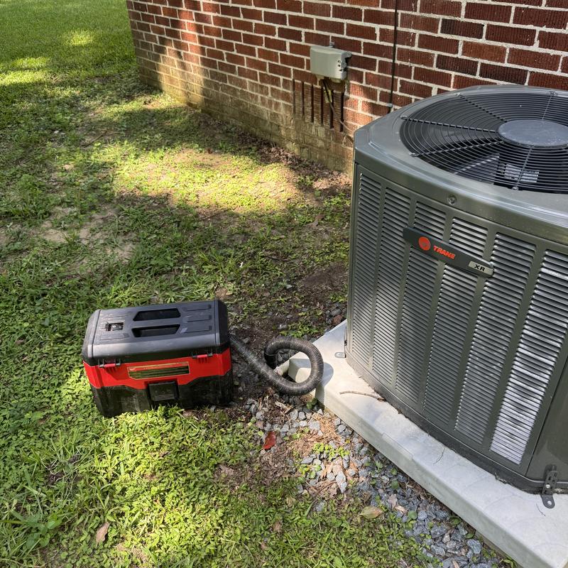 Residential split AC unit with maintenance tools outdoors