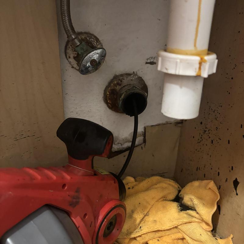 Drain line cleaning with drain auger under sink