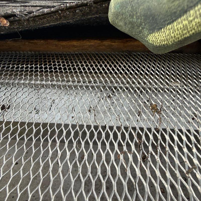 Metal gutter guard installation with debris buildup