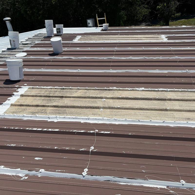 Metal roof panels with hail damage and sealant repairs