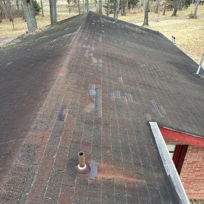 Asphalt shingle roof with visible hail damage patches
