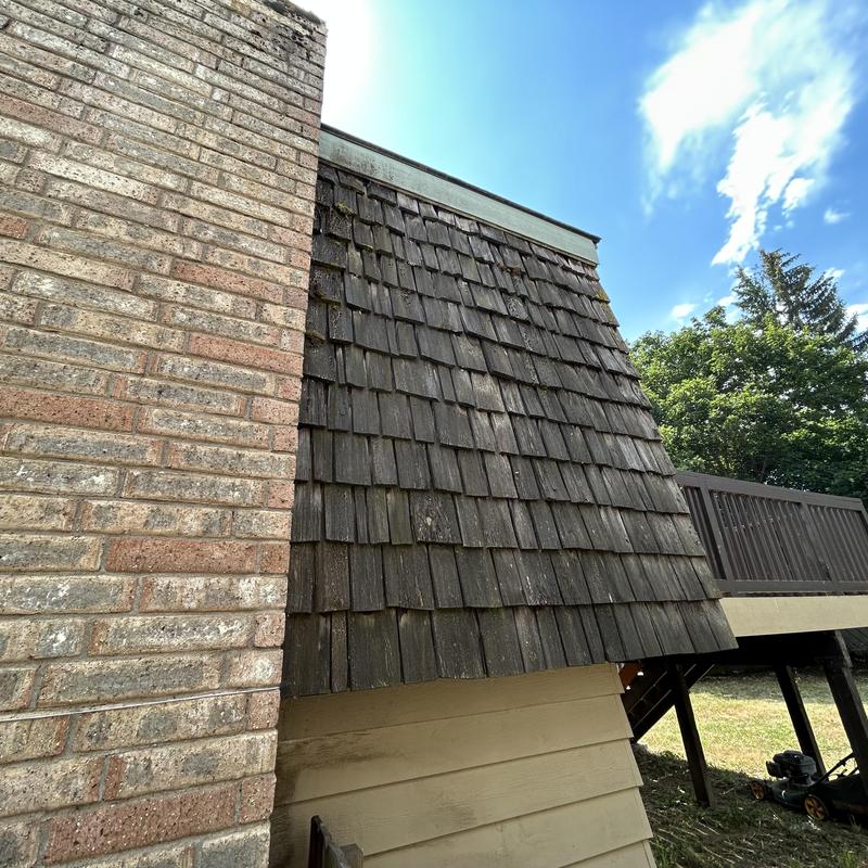 Wood shingle roof inspection next to brick chimney Wood shingle roof inspection next to brick chimney