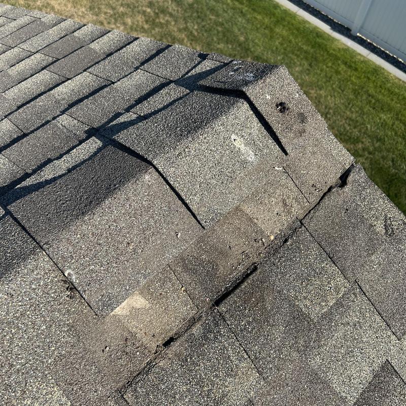 Asphalt shingle roof with repaired damaged ridge cap Asphalt shingle roof with repaired damaged ridge cap