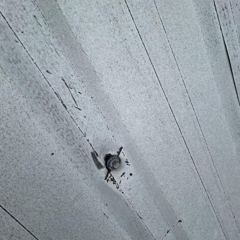 Metal roof panel with fastener and surface wear Metal roof panel with fastener and surface wear