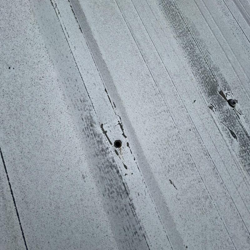 Metal roof panel with aged fastener holes Metal roof panel with aged fastener holes