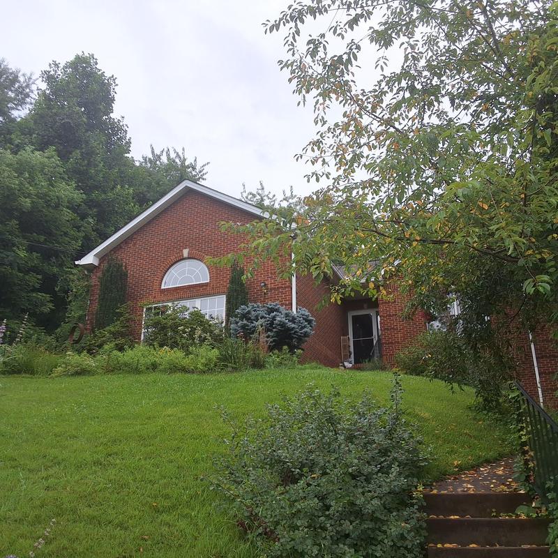Roof inspection on brick home with greenery
