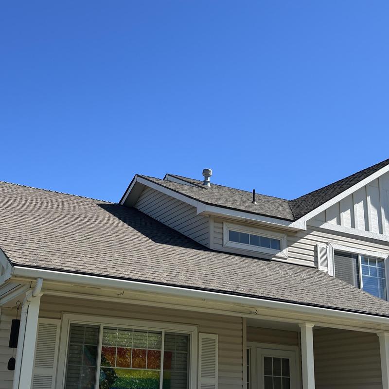Asphalt shingle roof on residential house with clear sky Asphalt shingle roof on residential house with clear sky