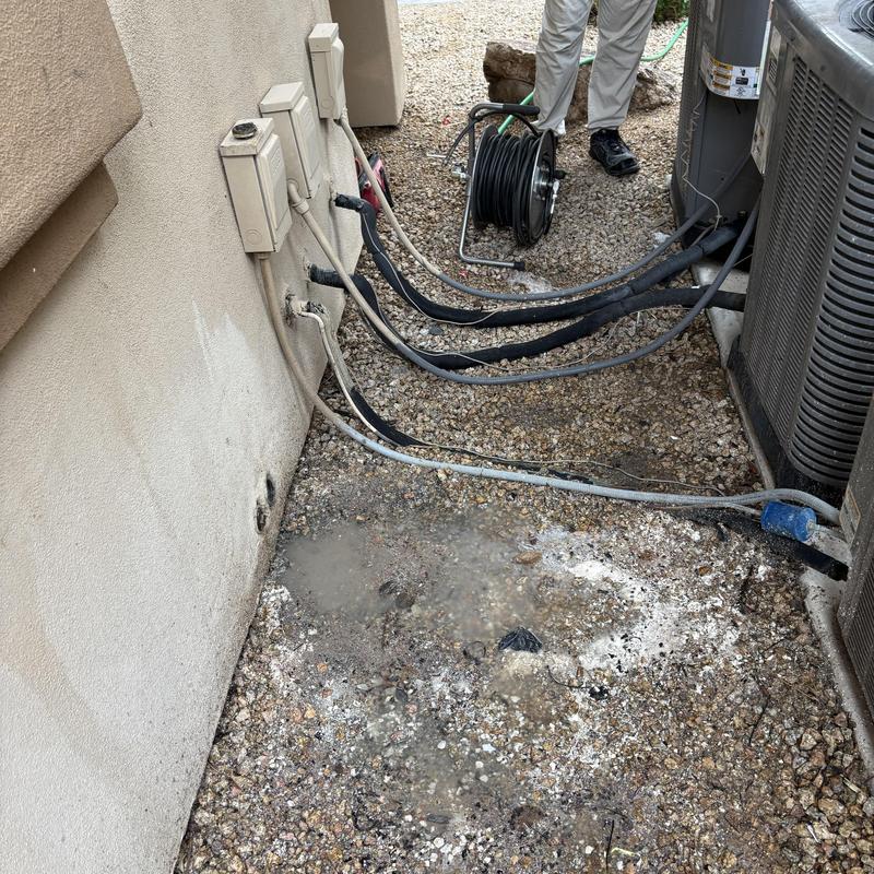Outdoor air conditioner drain water leak with hose and cables