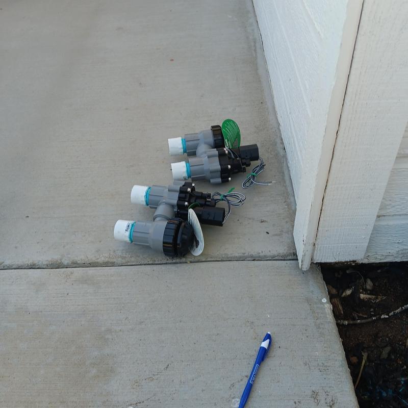 Sprinkler valves with wiring on concrete near wall