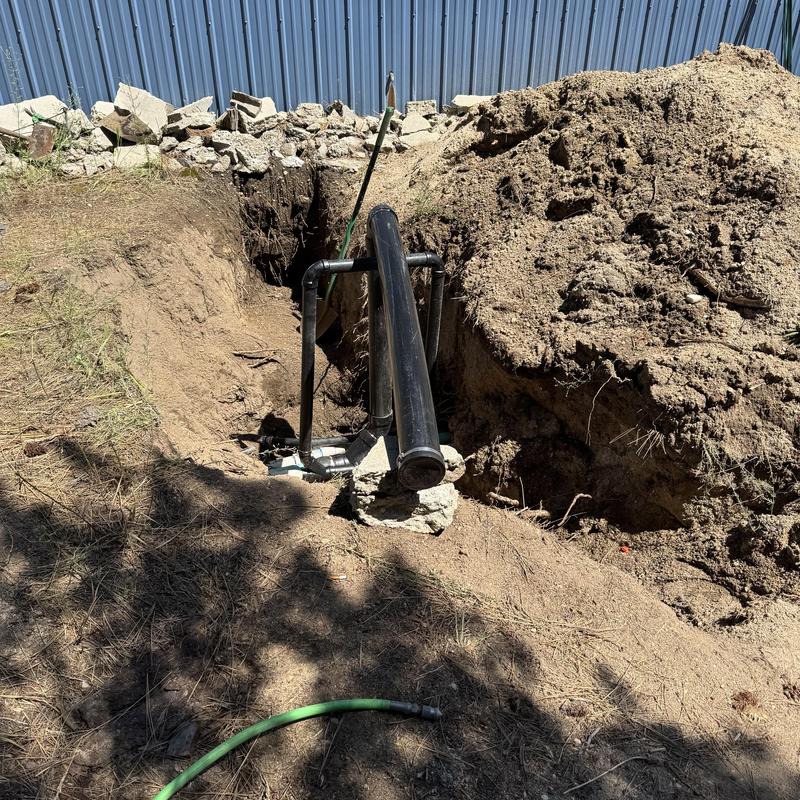 Sewer cleanout with exposed black PVC piping in dirt trench Sewer cleanout with exposed black PVC piping in dirt trench