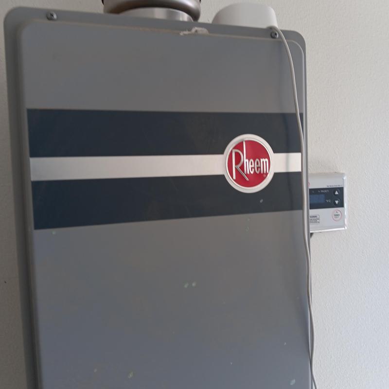 Rheem tankless water heater unit on wall