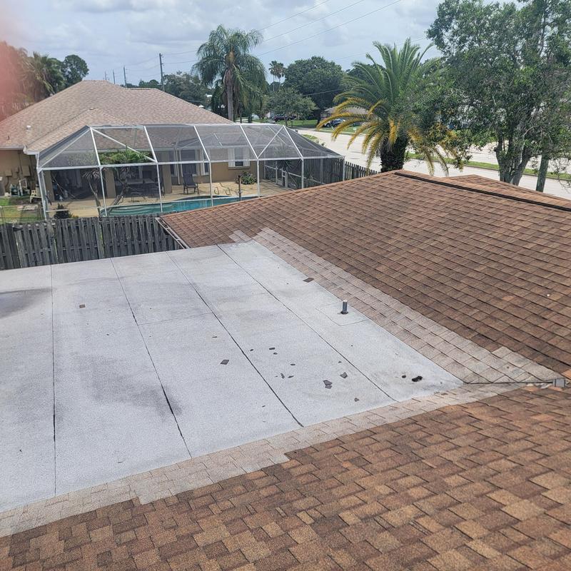 Flat roof with hail damage on shingle roof section Flat roof with hail damage on shingle roof section