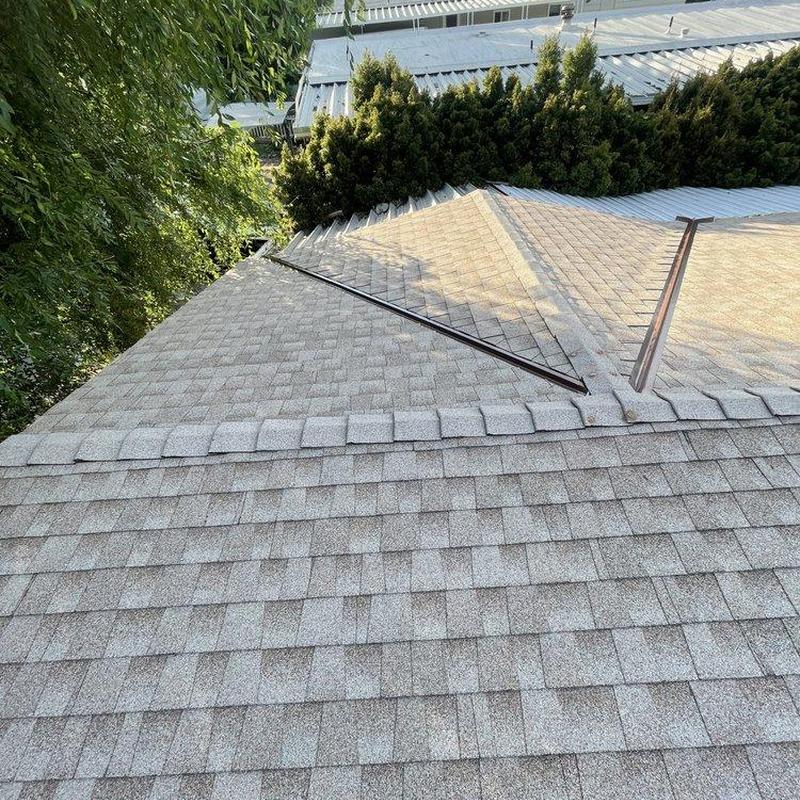 Asphalt shingle roof with metal ridge caps installation Asphalt shingle roof with metal ridge caps installation