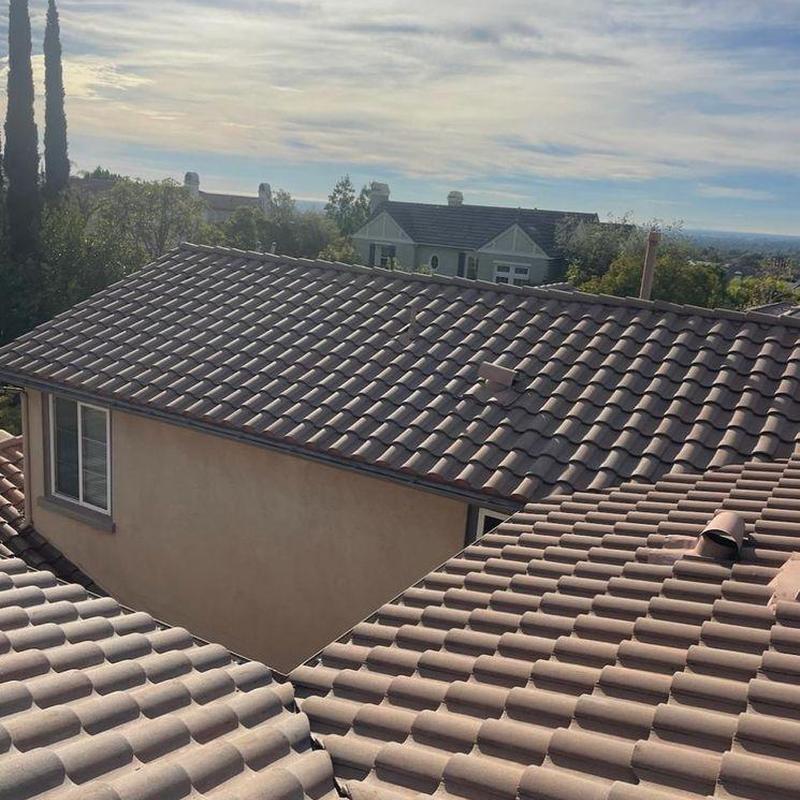 Tile roof with vent pipes and chimney nearby Tile roof with vent pipes and chimney nearby