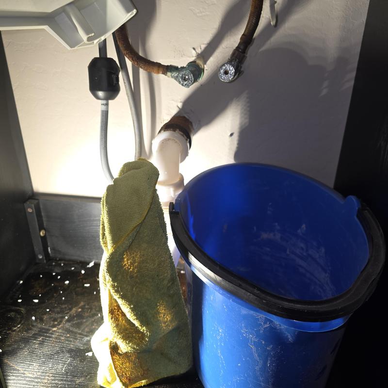 Angle stop valves on laundry sink with bucket and rag