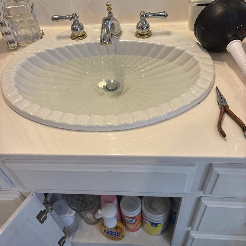 Bathroom sink drain with plunger and pliers nearby Bathroom sink drain with plunger and pliers nearby