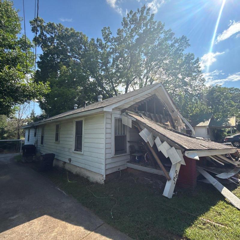 Roof framing collapsed with broken siding and decking