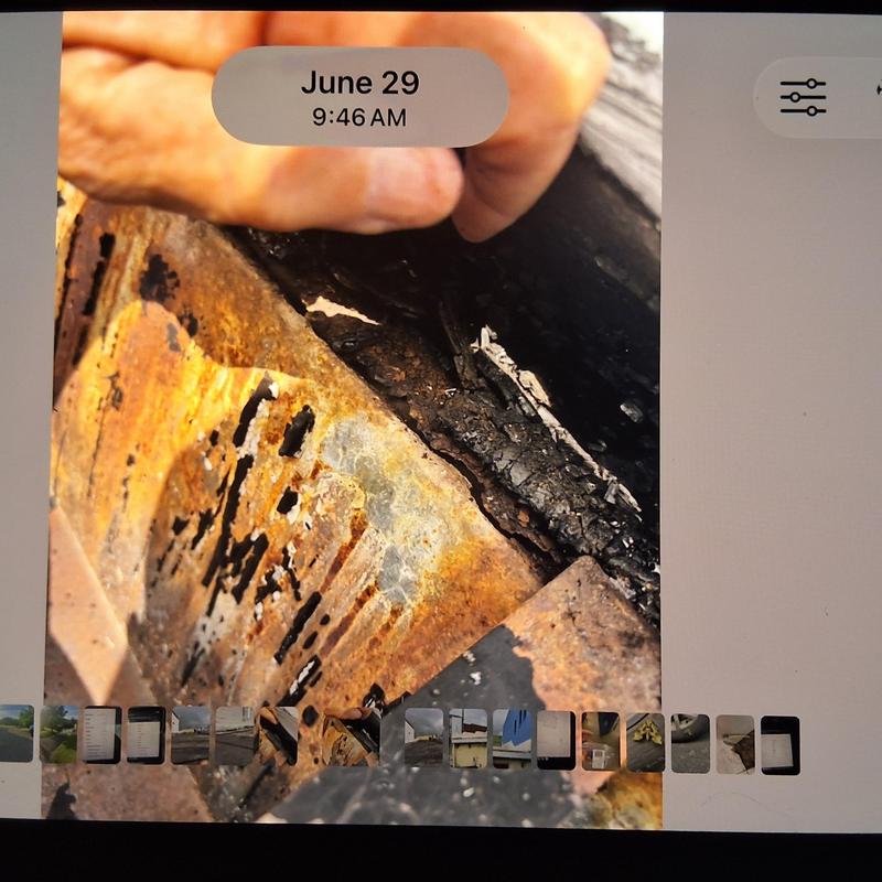 Rust-damaged metal flashing on flat commercial roof