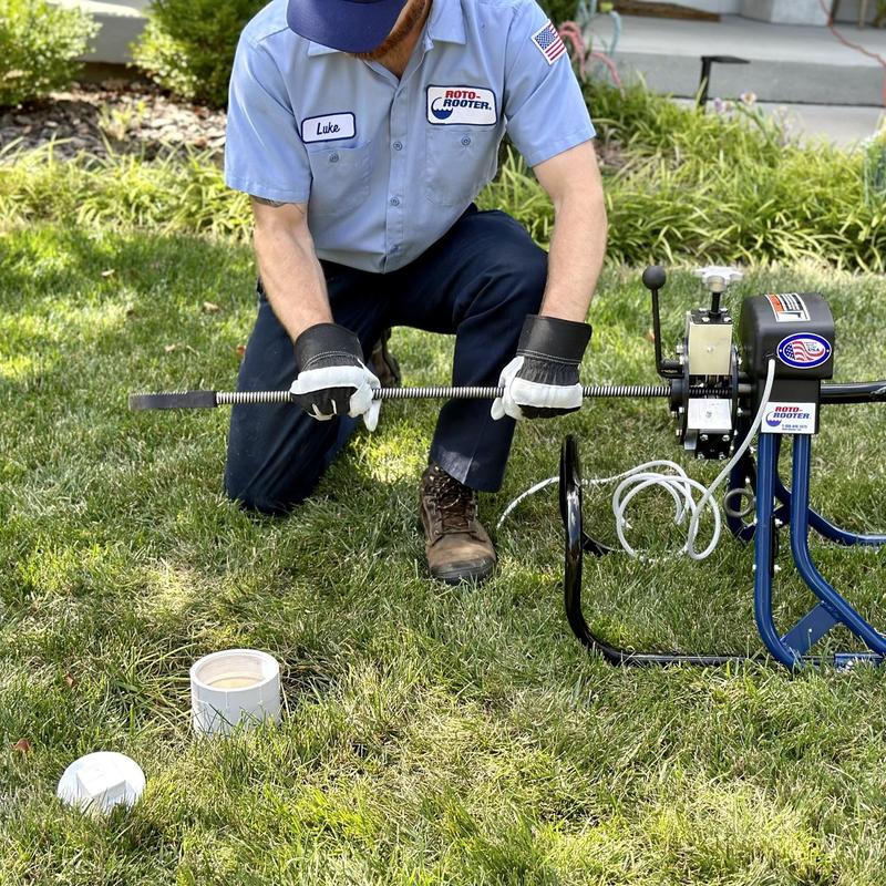 Sewer line cleaning with auger machine on grass