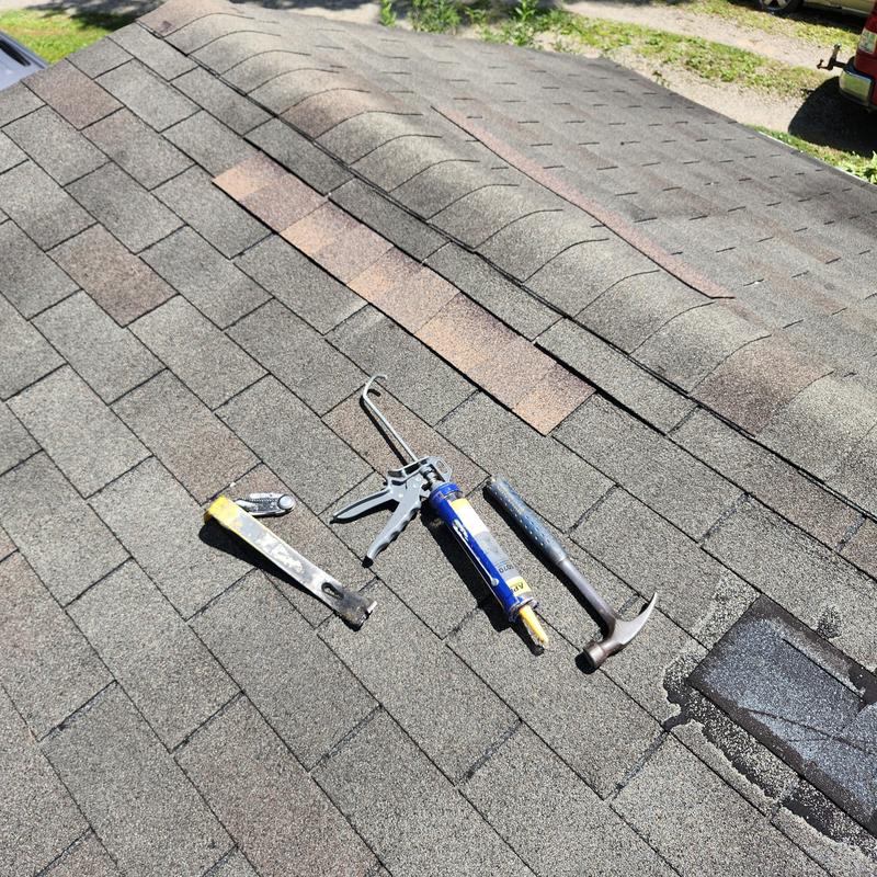 Shingled roof with vent boot and roofing tools