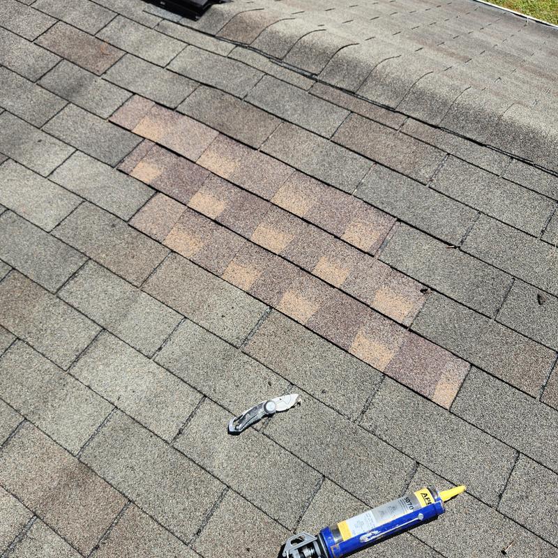 Roof shingles patch with utility knife and sealant tube