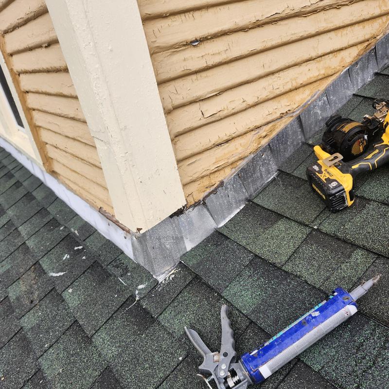 Step flashing installation on dormer roof corner with tools