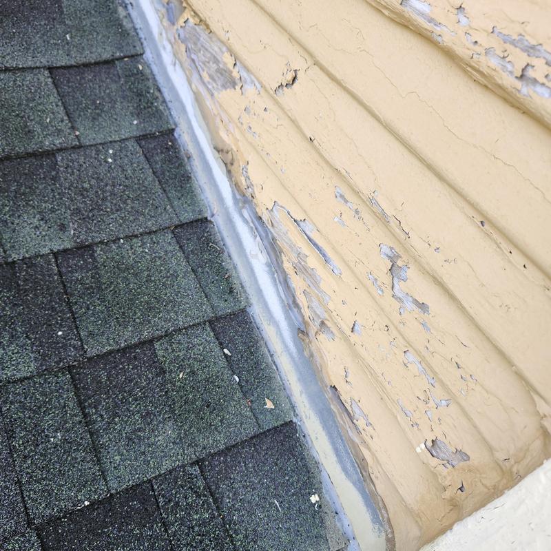 Step flashing along roof and siding with peeling paint