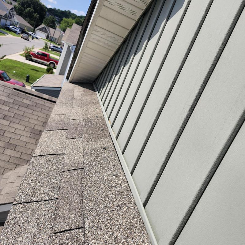 Asphalt shingles roof with loose shingles near siding