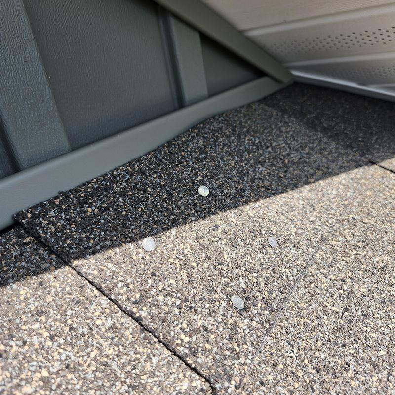 Roof shingles secured and sealed near metal flashing