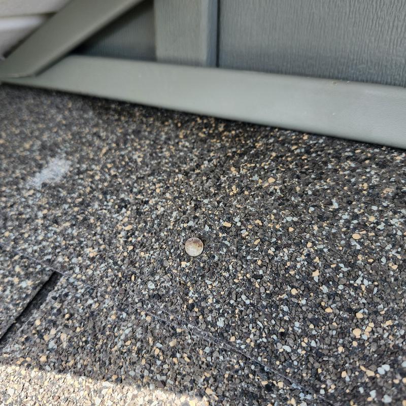 Asphalt shingles with sealed nail heads near trim