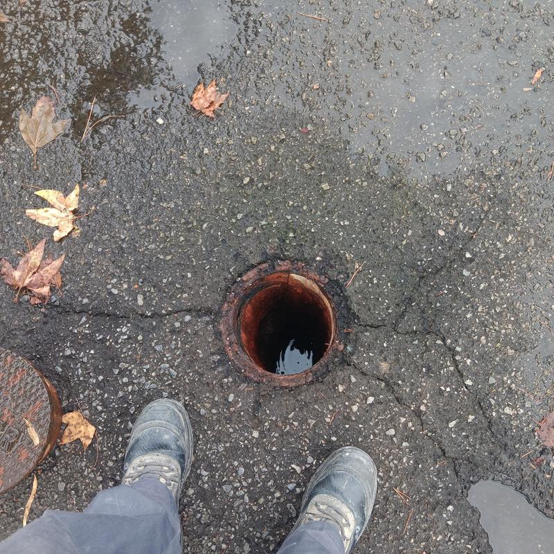 Water main leak detection hole in paved lot Water main leak detection hole in paved lot