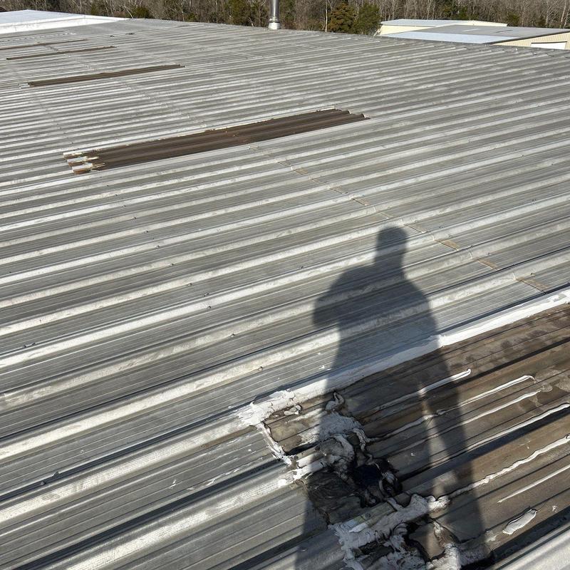 Metal roof panel with patch and sealant damage
