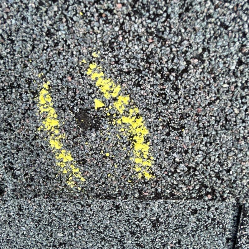 Roof shingle with yellow chalk hail damage marking
