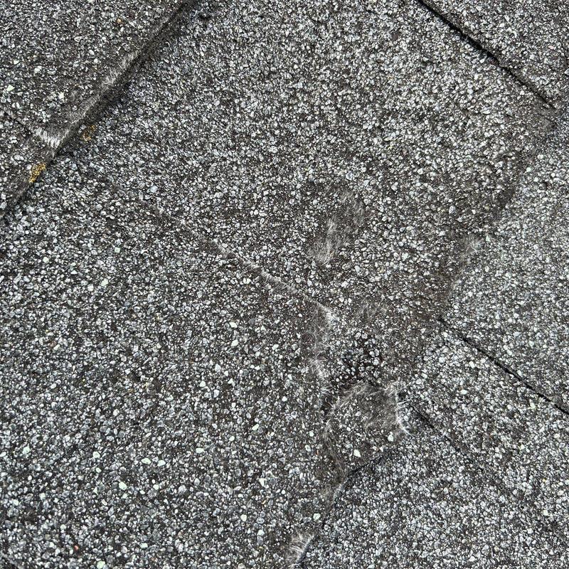 Granite roofing shingles with hail damage close-up