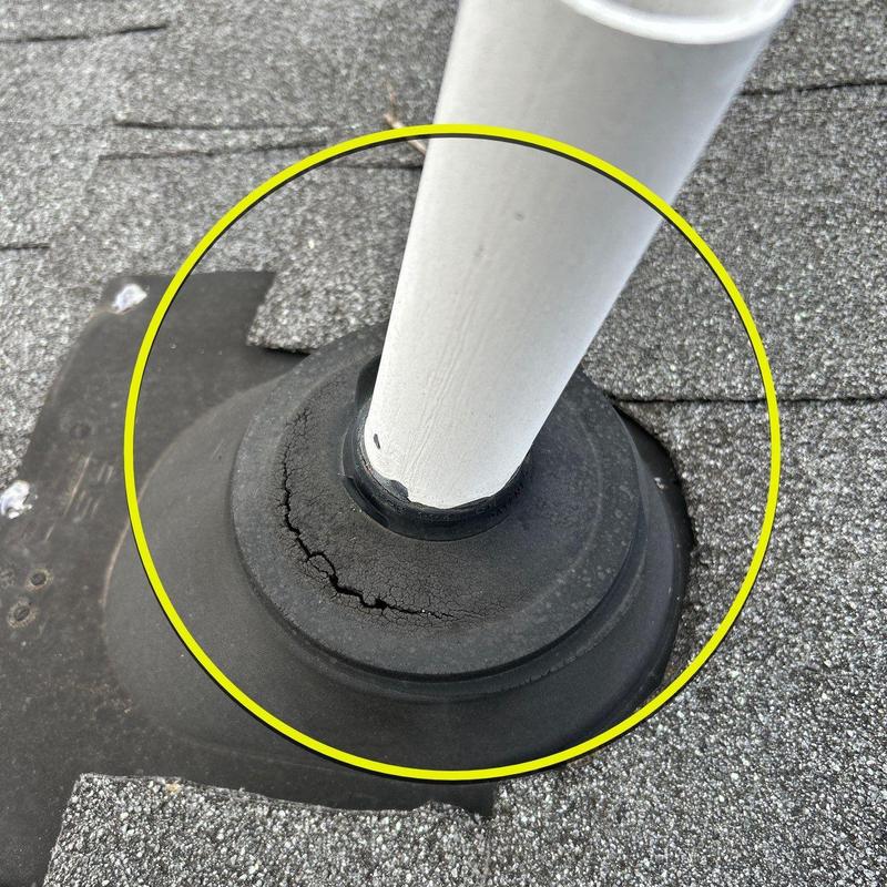 Roof pipe flashing with visible cracks on shingle roof
